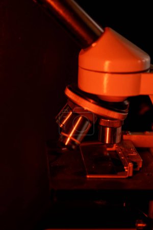 Foto de Lentes de microscopio médico de cerca, en luz roja cálida - Imagen libre de derechos