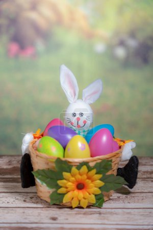 Foto de Una estatua de un conejo sosteniendo huevos de Pascua de colores. Concepto Domingo de Pascua, Pascua o Resurrección - Imagen libre de derechos