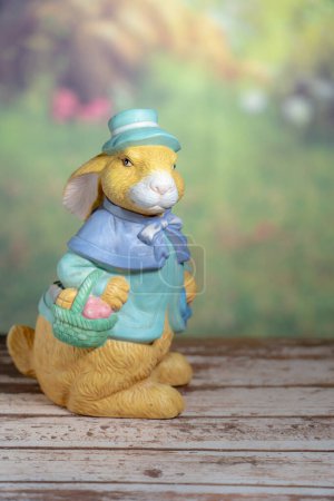 Photo for A statue of a rabbit holding colored Easter eggs. Easter, Pascha or Resurrection Sunday concept - Royalty Free Image