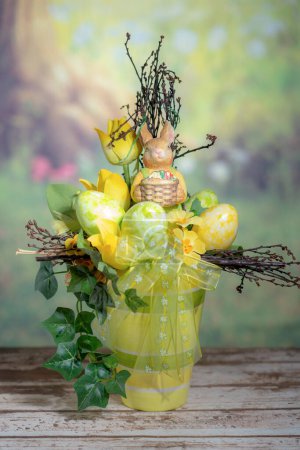 Foto de Una estatua de un conejo sosteniendo huevos de Pascua de colores. Concepto Domingo de Pascua, Pascua o Resurrección - Imagen libre de derechos