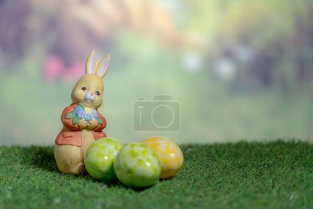 Photo for A statue of a rabbit holding colored Easter eggs. Easter, Pascha or Resurrection Sunday concept - Royalty Free Image