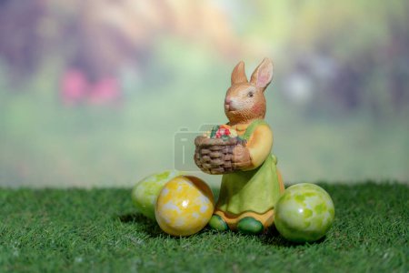 Téléchargez les photos : Statue d'un lapin tenant des œufs de Pâques colorés. Dimanche de Pâques, Pâques ou Résurrection concept - en image libre de droit