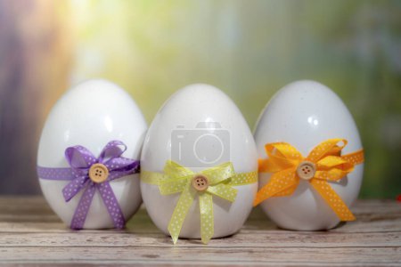 Foto de 3 huevos envueltos en una corbata de regalo de colores. Concepto Domingo de Pascua, Pascua o Resurrección - Imagen libre de derechos