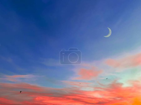 Téléchargez les photos : Fond islamique avec croissant de lune en soirée avec ciel crépusculaire coloré, nuit bleue Ramadan avec coucher de soleil dramatique. - en image libre de droit