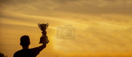 Photo for Banner Winner win hands holding golden champion trophy cup prize. Silhouette best award victory hands champion trophy . Panorama Team holding gold sport trophy cup. Win-Win sport team with copy space - Royalty Free Image