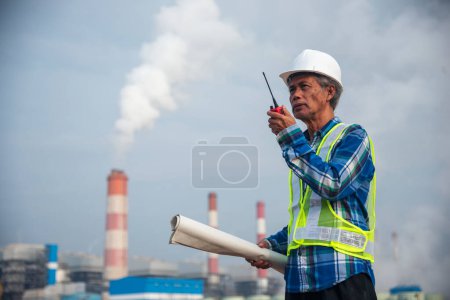 Photo for Senior Electrician engineer man hand holding red Walkie talkie communicate wear White hardhat at Power stations manufacturing electrical plant. Technician worker blue hard hat helmet Engineer industry - Royalty Free Image