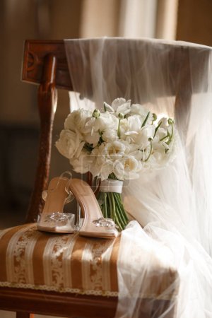 Téléchargez les photos : Chaussures de mariage et bouquet de mariée sur une chaise vintage - en image libre de droit