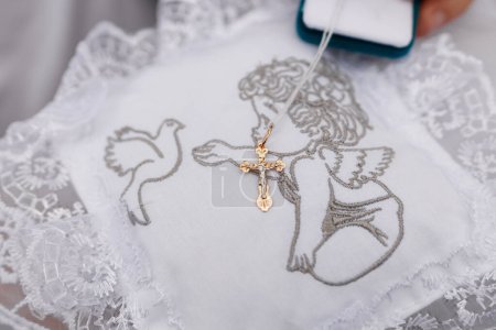 embroidered white napkin with an angel and a gold baptismal cross