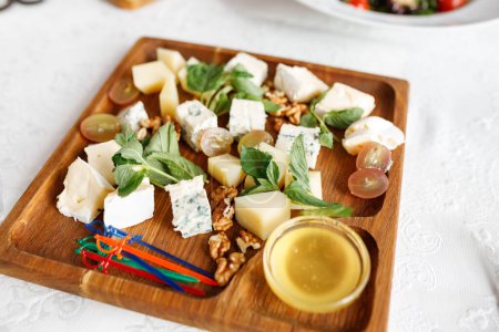 Téléchargez les photos : Assiette au fromage. Gorgonzola, fromage à pâte dure, raisins, miel, noix - en image libre de droit