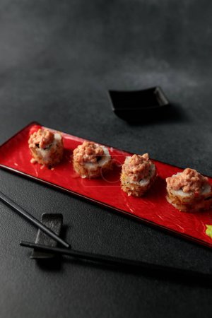 Shiitaki roll takes center stage against a black background. Filled with tuna, avocado, Philadelphia cheese, kimchi, and tuna flakes, it's a vibrant and flavorful representation of Japanese cuisine. this picture beautifully captures the essence of su