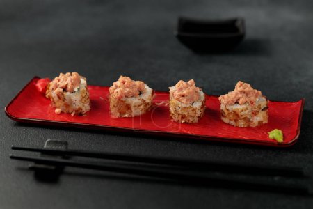 Shiitaki roll takes center stage against a black background. Filled with tuna, avocado, Philadelphia cheese, kimchi, and tuna flakes, it's a vibrant and flavorful representation of Japanese cuisine. this picture beautifully captures the essence of su