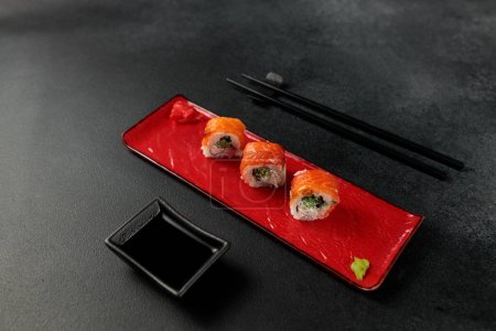 a classic Philadelphia roll, featuring shrimp and salmon, takes center stage against a sleek black backdrop. It's a mouthwatering representation of Japanese cuisine