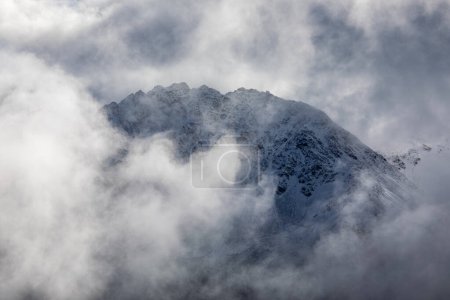 Téléchargez les photos : Le sommet de la montagne émerge à travers les nuages brumeux des Alpes suisses près de Davos, en Suisse - en image libre de droit