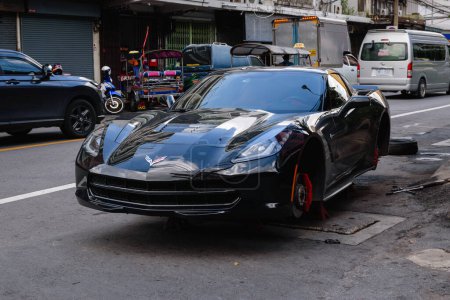 Photo for Black Chevrolet Corvette without wheels on the street in Chinatown, Bangkok - Royalty Free Image