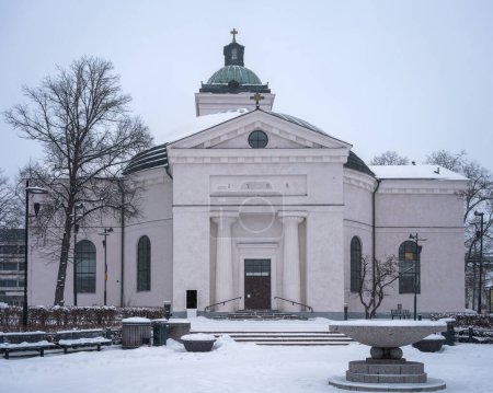 Téléchargez les photos : Eglise de Hameenlinna en hiver, couverte de neige par une journée nuageuse. Hameenlinna, Finlande. - en image libre de droit