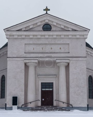 Téléchargez les photos : Entrée de l'église de Hameenlinna en hiver, couverte de neige par temps nuageux. Hameenlinna, Finlande. - en image libre de droit