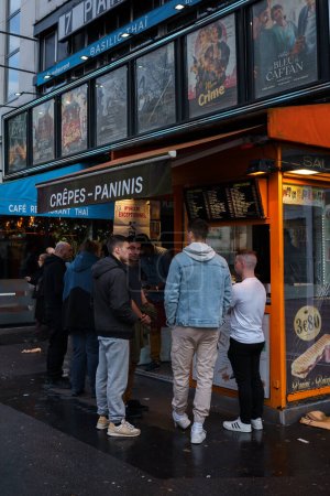 Téléchargez les photos : Des gens attendent devant la boutique de crêpes et paninis à Paris, en France. 24 mars 2023. - en image libre de droit