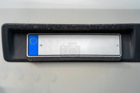 Plaque d'immatriculation européenne vide à l'arrière d'un van blanc, photo rapprochée.