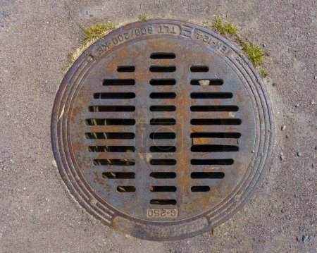 Téléchargez les photos : Couvercle rond de drain pluvial métallique sur asphalte, vue de dessus gros plan. - en image libre de droit