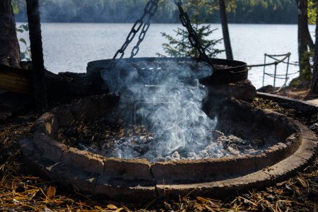 Rauchendes Lagerfeuer, Feuerstelle im Lapakisto Nature Reserve, Lahti, Finnland.