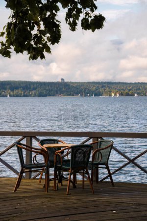 Photo for Table for four on the dock next to a lake. - Royalty Free Image