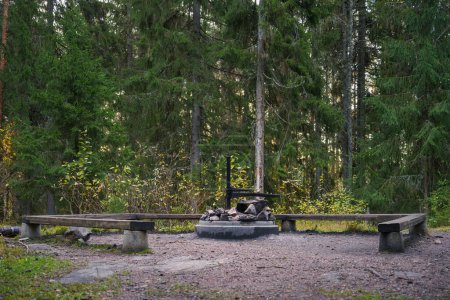 Foto de Sitio de fogata vacío con bancos de madera y la fogata de hormigón, vista lateral. Hollola, Finlandia. - Imagen libre de derechos