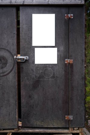 Foto de Dos carteles vacíos en la puerta de un viejo cobertizo de madera contrachapada en el bosque. - Imagen libre de derechos