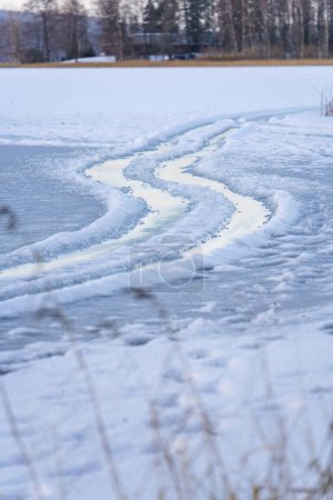 Wet tire tracks on a frozen lake, close up