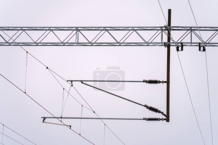Elektrische Freileitungen vor wolkenverhangenem Himmel für die Stromversorgung der Bahn