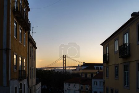 Brücke 25 de Abril von den Gebäuden im Sonnenuntergang aus gesehen