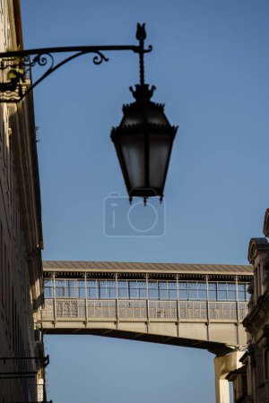 Walkway of the Santa Justa Lift in Lisbon, Portugal and out of focus antique street light in the foreground
