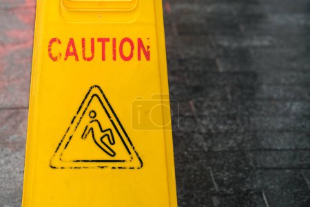 Close-up of a worn-out wet floor warning sign.
