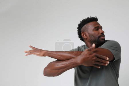 Photo for African American athletic man doing muscle stretching exercises. Mock-up. High quality photo. - Royalty Free Image