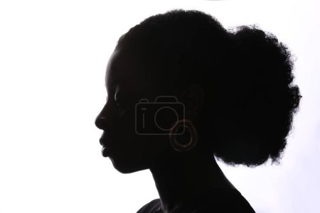 Photo for Young African American woman confidently looks at camera has simple expression reveals depth of thought and contemplation poses over white background. - Royalty Free Image