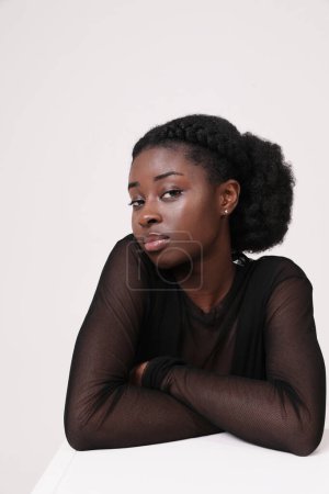 Beautiful young African American woman confidently looks at camera. Isolated. High quality photo.