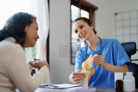 Foto de Retrato de una doctora hablando con un paciente anciano sobre la osteoartritis - Imagen libre de derechos