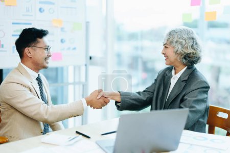 Photo for Asian entrepreneurs handshakes to congratulate the agreement between the two companies to enhance investment and financial strength. deal concept. - Royalty Free Image