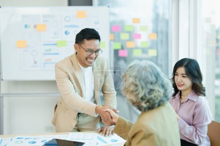 Asian entrepreneurs handshakes to congratulate the agreement between the two companies to enhance investment and financial strength. deal concept.-stock-photo
