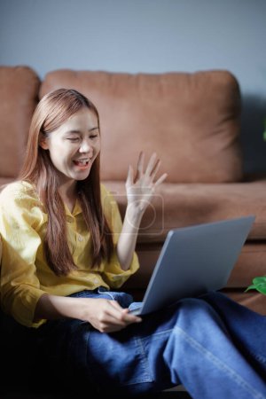Portrait of a beautiful Asian teenage girl using a computer. Poster 648157956