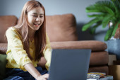 Portrait of a beautiful Asian teenage girl using a computer. Poster #648160194