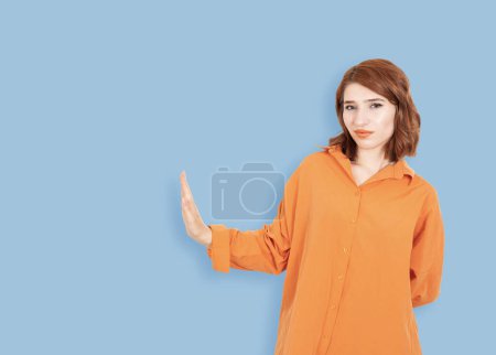 Téléchargez les photos : Affichage stop signe de côté, portrait de la jeune femme aux cheveux roux caucasienne montrant stop signe de côté. Va-t'en. dérangé, nie, ignore, n'aime pas, mécontent, froncer les sourcils concept idée image. Espace de copie. - en image libre de droit