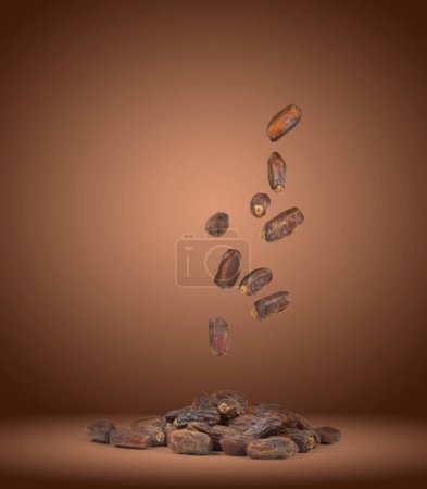 Flying, dropping dry date fruits like raining. Conceptional image of delicious special nutrition for islam religious holy month ramadan snacks. Dark brown background, copy space. 