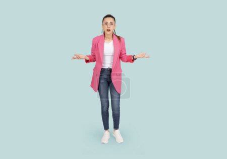 What is your problem? Pissed off frustrated  angry business woman full body length studio portrait. Shrugging brunette confused annoyed female wear pink formal jacket and denim jean. Can't understand