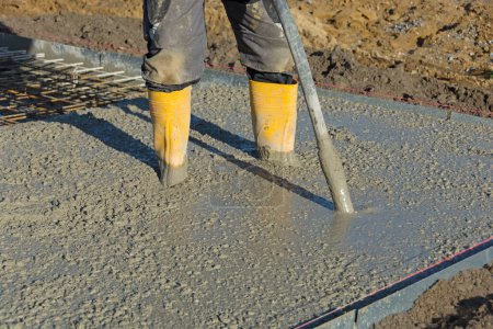 Photo for Concrete is compacted by builder with concrete vibrator - Royalty Free Image