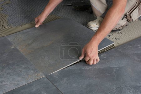 Photo for A tiler laid floor tile - Royalty Free Image