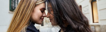 Téléchargez les photos : Vue latérale du couple lesbienne heureux en vêtements de dessus debout face à face à l'extérieur, bannière horizontale - en image libre de droit