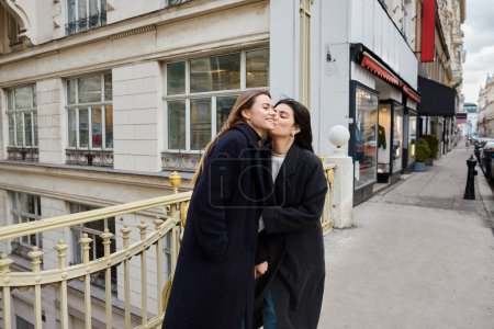 Téléchargez les photos : Moment intime de femmes lesbiennes heureuses en amour debout ensemble dans la rue dans la ville européenne - en image libre de droit