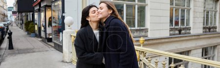 Foto de Momento íntimo de mujeres lesbianas felices enamoradas de pie juntas en la calle en la ciudad europea, pancarta - Imagen libre de derechos