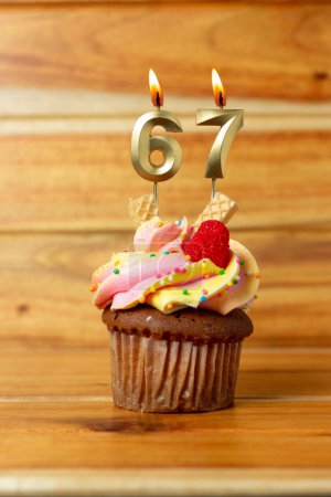 Foto de Vela de cumpleaños dorada sobre fondo de madera - Magdalena de cumpleaños con vela numerada - Imagen libre de derechos
