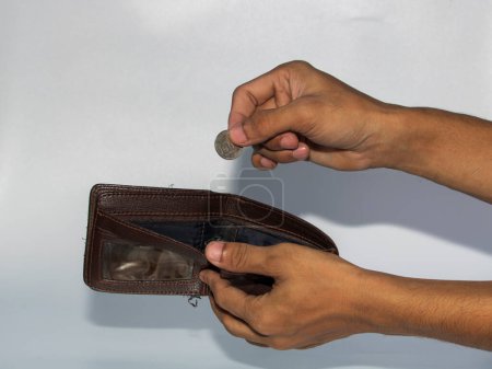 Foto de Jakarta, Indonesia - 08 de noviembre de 2022: la mano de un hombre toma y muestra dinero de una billetera aislada sobre un fondo blanco, la rupia es la moneda de Indonesia - Imagen libre de derechos